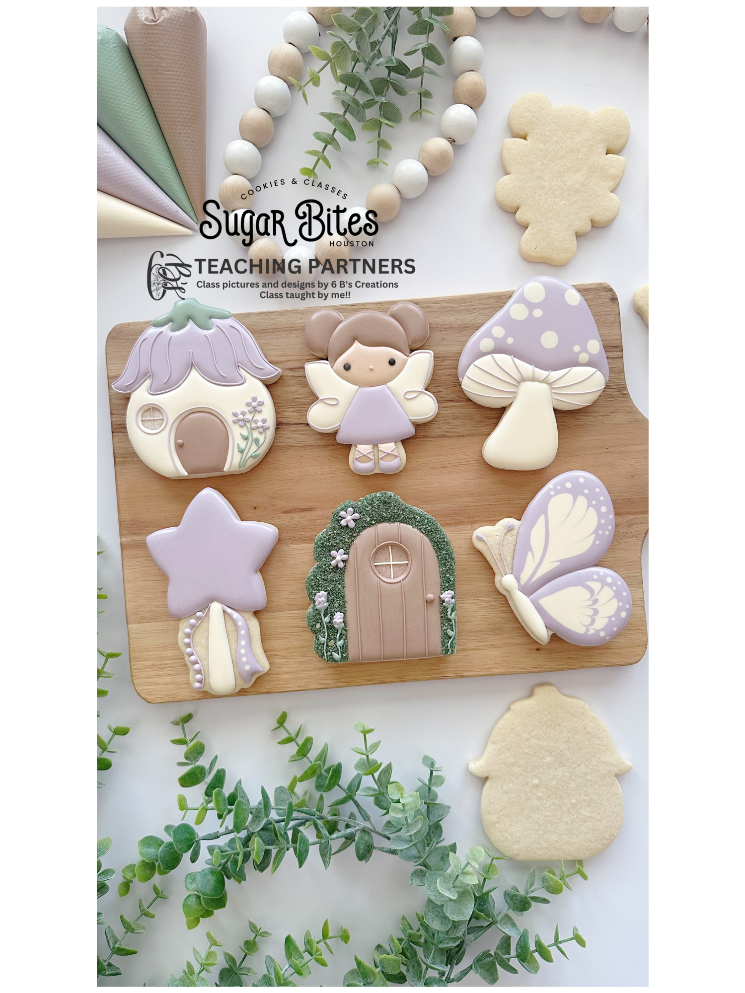 Pastel fairy garden themed sugar cookies decorated with royal icing, including a fairy house, fairy character, butterfly, mushroom, star wand, and enchanted door, arranged on a wooden board for an April cookie decorating class.